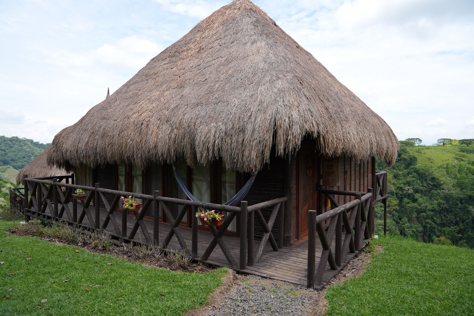 Cabaña con techo de paja frente a las montañas